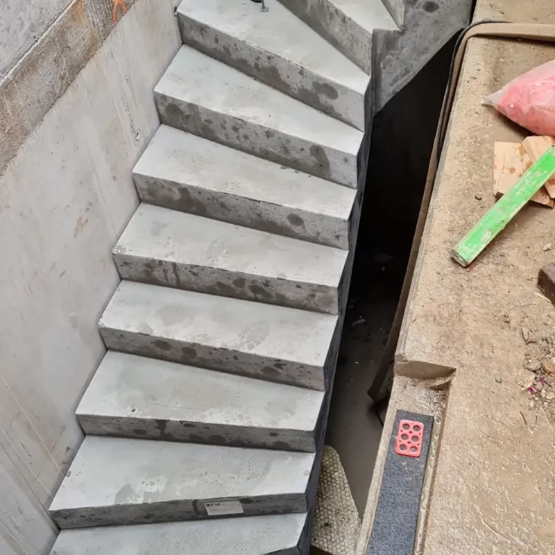 Diese Betonarbeiten-Treppe verfügt über kein Sicherheitsgeländer und könnte bei der Benutzung ein Sicherheitsrisiko darstellen.